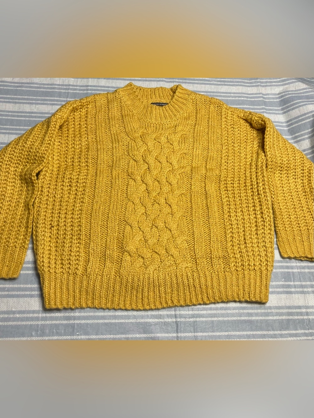 Chelsea & Theodore mustard cable-knit sweater.
